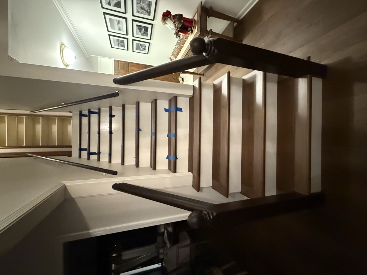 Classic hardwood staircase with dark railing